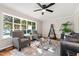 Bright living room with large window, neutral color scheme, ceiling fan, and modern furniture at 1701 Pinedale Dr, Raleigh, NC 27603
