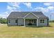 Charming home featuring a covered patio, outdoor dining area, and a spacious backyard, perfect for outdoor entertaining at 194 Spring Hill Church Rd, Lillington, NC 27546