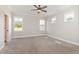 Bright bedroom featuring plush carpet, ceiling fan, and three windows providing natural light at 194 Spring Hill Church Rd, Lillington, NC 27546