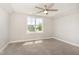 Bright bedroom with neutral carpet, ceiling fan, and a large window offering serene views at 194 Spring Hill Church Rd, Lillington, NC 27546