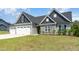 Beautiful two-story home with a three-car garage, stone detailing, and a freshly cut lawn at 194 Spring Hill Church Rd, Lillington, NC 27546