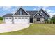 Attractive two-story home featuring a three-car garage, stone accents, and a green lawn at 194 Spring Hill Church Rd, Lillington, NC 27546