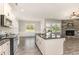 Open kitchen featuring an island, stainless steel appliances, and a seamless flow into the living area with a stone fireplace at 194 Spring Hill Church Rd, Lillington, NC 27546