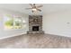 Inviting living room features a stone fireplace, ceiling fan, and hardwood floors at 194 Spring Hill Church Rd, Lillington, NC 27546