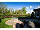 Beautifully landscaped backyard features a stone fire pit and barbecue grill at 20 Al Aqua Dr, Durham, NC 27707
