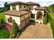Lovely stucco house with a tile roof and a brick driveway surrounded by greenery at 20 Al Aqua Dr, Durham, NC 27707