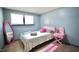 Cozy bedroom featuring neutral walls, wood floors, and a fun pink accent mirror for a playful touch at 2006 Waters Dr, Raleigh, NC 27610