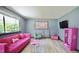 Stylish living room featuring a vibrant pink couch, playful decor, and lots of natural light at 2006 Waters Dr, Raleigh, NC 27610