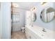 Bright bathroom featuring double sinks, a toilet, and a washing machine with patterned curtain at 206 Lane Of Tristram, Garner, NC 27529