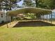 Spacious carport providing covered parking, surrounded by a green lawn and mature trees at 206 Lane Of Tristram, Garner, NC 27529
