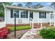 Charming front entrance with brick steps, a stone pathway, and black shutters on a gray house at 206 Lane Of Tristram, Garner, NC 27529
