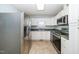 Well-lit kitchen with white cabinets, stainless steel appliances, and neutral tile flooring at 206 Lane Of Tristram, Garner, NC 27529