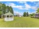 Spacious backyard featuring a gazebo, shed, lush lawn, trees, and a well-manicured landscape at 208 E Harrington Ave, Broadway, NC 27505