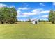 Expansive backyard featuring a shed, mature trees, lush lawn, and a serene outdoor space at 208 E Harrington Ave, Broadway, NC 27505