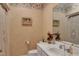 Charming bathroom featuring decorative wallpaper, a white vanity, and a well-lit mirror at 208 E Harrington Ave, Broadway, NC 27505