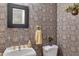 Charming powder room featuring a pedestal sink, patterned wallpaper, and classic fixtures at 208 E Harrington Ave, Broadway, NC 27505