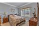 Comfortable bedroom with a patterned quilt, wooden furniture, and a window for natural light at 208 E Harrington Ave, Broadway, NC 27505