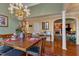 Dining room with a wooden table, chandelier, and view of the living room with fireplace at 208 E Harrington Ave, Broadway, NC 27505