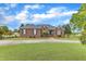 Beautiful single-story brick home with a well-maintained lawn, manicured landscaping, and a winding driveway at 208 E Harrington Ave, Broadway, NC 27505
