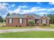 Charming brick home with lush green lawn, manicured landscaping, and concrete driveway at 208 E Harrington Ave, Broadway, NC 27505