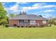 A sprawling green lawn complements this red brick home with screened-in porch and white trim at 208 E Harrington Ave, Broadway, NC 27505