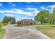 Charming brick home featuring a well-manicured lawn, gazebo, and inviting circular driveway, ideal for Gathering and entertaining at 208 E Harrington Ave, Broadway, NC 27505