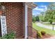 Exterior detail showcasing brickwork, a column, and a glimpse of the well-maintained yard at 208 E Harrington Ave, Broadway, NC 27505