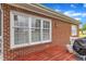 Exterior view of red brick house with white window trim and dark wood deck at 208 E Harrington Ave, Broadway, NC 27505