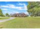 Charming one-story brick home with a curved driveway, mature trees, and a beautifully landscaped yard at 208 E Harrington Ave, Broadway, NC 27505