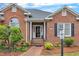 Inviting front entrance with brick walkway, manicured landscaping, and a charming flower wreath at 208 E Harrington Ave, Broadway, NC 27505