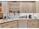 Close-up of the kitchen showcasing white cabinets, countertops, sink, and modern appliances, with open shelving at 208 E Harrington Ave, Broadway, NC 27505
