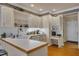 Bright kitchen featuring white cabinetry, open shelving, and a peninsula with a breakfast bar and wood floors at 208 E Harrington Ave, Broadway, NC 27505