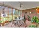 Enclosed brick patio with a ceiling fan, table, chairs, and views of the yard at 208 E Harrington Ave, Broadway, NC 27505
