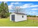 Well-maintained storage shed with gray doors, a window, and ample yard space around it at 208 E Harrington Ave, Broadway, NC 27505