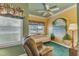 Bright sunroom with a mural, comfortable seating, and natural light streaming through the windows at 208 E Harrington Ave, Broadway, NC 27505