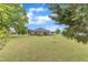 Huge green backyard with trees surrounding a beautiful brick home with screened-in porch at 208 E Harrington Ave, Broadway, NC 27505