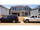 Two story home with attached garage and blue and gray siding under clear sky in developing neighborhood at 2227 Cherry Creek Rd, Haw River, NC 27258
