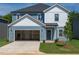 Charming two-story home featuring blue siding, a spacious two-car garage, and a well-manicured front yard at 2233 Cherry Creek Rd, Haw River, NC 27258