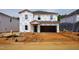 New two-story home under construction with Tyvek wrap and a two car garage at 2239 Cherry Creek Rd, Haw River, NC 27258