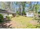 View of the backyard showcasing the shed, large trees, and green grass at 2343 Derby Dr, Raleigh, NC 27610