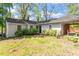 View of the back of the home showcasing the yard, covered parking, and mature trees at 2343 Derby Dr, Raleigh, NC 27610