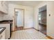 Functional kitchen showing the black and white tile floor, white cabinets, and access to other rooms at 2343 Derby Dr, Raleigh, NC 27610