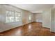 A vacant living room showcasing hardwood floors, natural light, and plain white walls at 2343 Derby Dr, Raleigh, NC 27610
