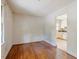 An empty room displaying hardwood floors, a plain canvas, and a view into the kitchen at 2343 Derby Dr, Raleigh, NC 27610