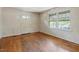 A basic, empty living room featuring hardwood floors, windows, and a blank canvas for personalization at 2343 Derby Dr, Raleigh, NC 27610