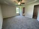 A bedroom with carpet flooring, tray ceiling with fan, and walk-in closet at 261 Phil Jack Rd, Dunn, NC 28334