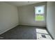 Sun-filled bedroom with plush carpeting and a window overlooking a green landscape at 261 Phil Jack Rd, Dunn, NC 28334