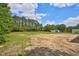 Vacant backyard, partially cleared, with a beautiful tree line and sunny skies at 2820 Tara Dr, Clayton, NC 27520