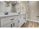 Modern bathroom with double sinks, quartz countertops, white cabinets, and wood-look flooring at 2820 Tara Dr, Clayton, NC 27520