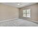 Bright bedroom with a ceiling fan, carpeted floor, and window view to a tree lined lot at 2820 Tara Dr, Clayton, NC 27520